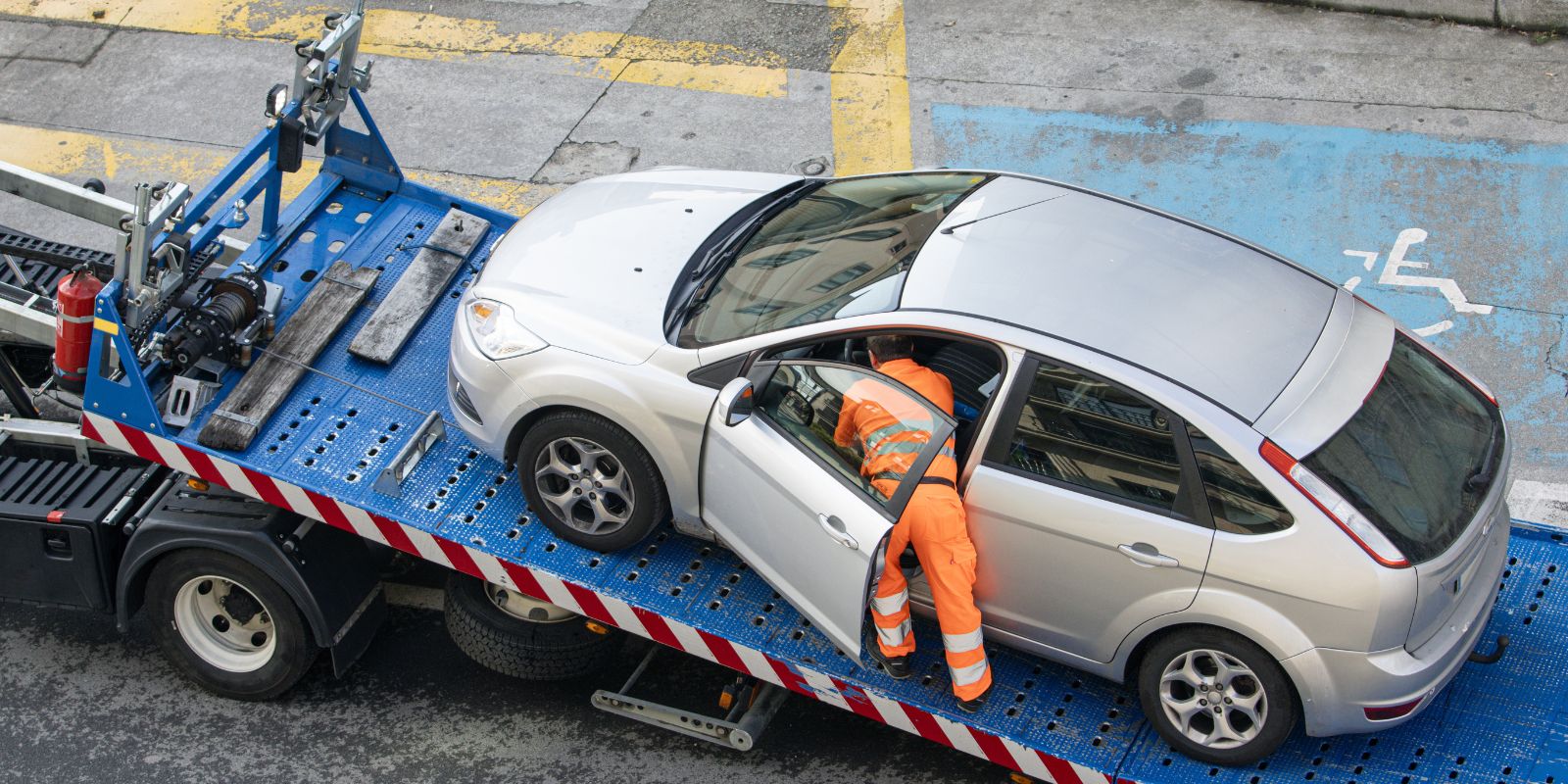 Operator lawety zabezpieczający uszkodzone auto do transportu po awarii lub kolizji